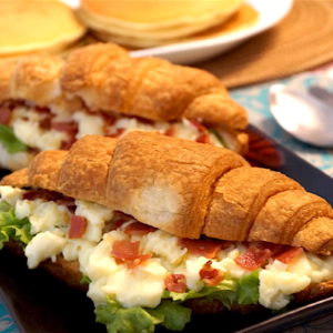 croissant sandwich with scrambled eggs cheese and bacon